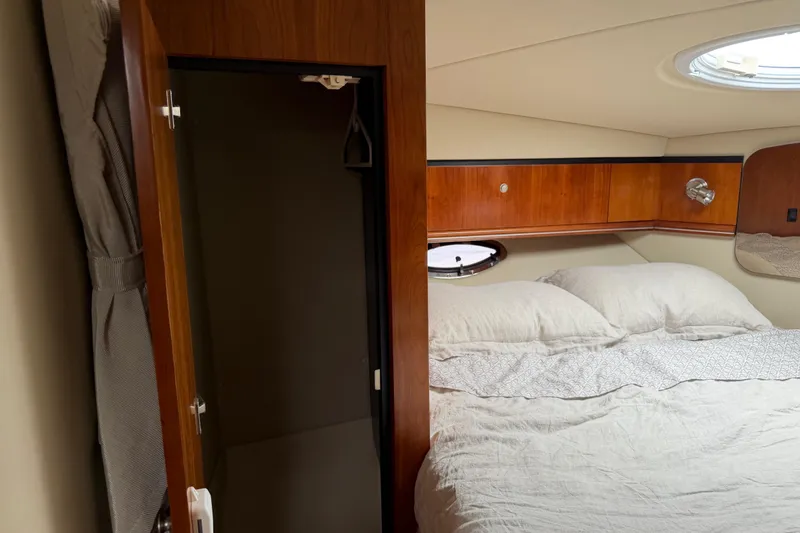 Slide: The Image of 2007 Cruisers 340 Express cabin interior with bed and wooden storage. - 30