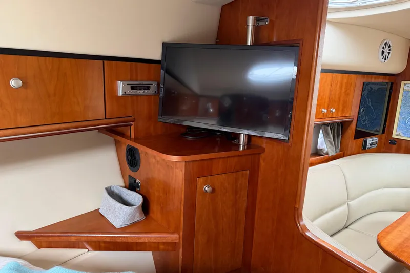 Slide: The Image of 2007 Cruisers 340 Express cabin interior with TV, wood paneling, and seating area. - 31