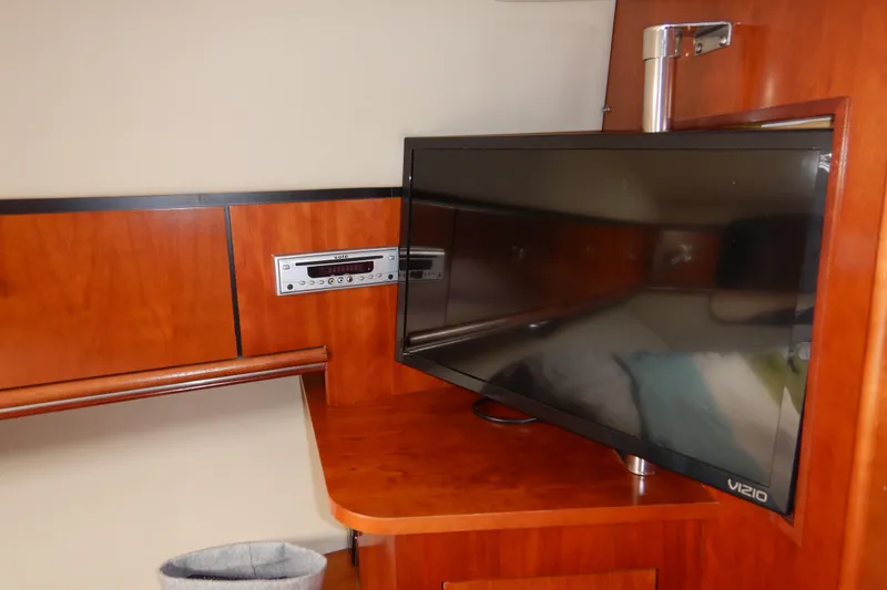 Slide: The Image of 2007 Cruisers 340 Express interior with TV and audio system on wooden paneling. - 32