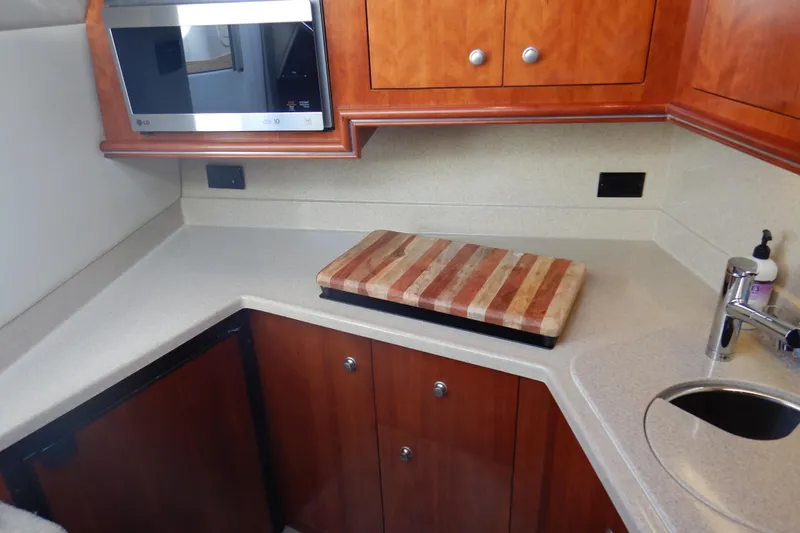 Slide: The Image of 2007 Cruisers 340 Express yacht kitchen with microwave, cutting board, and sink. - 34
