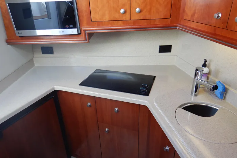 Slide: The Image of 2007 Cruisers 340 Express yacht kitchen with modern appliances and wooden cabinetry. - 35