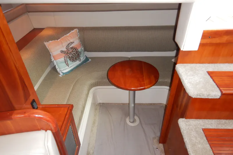 Slide: The Image of 2007 Cruisers 340 Express cabin interior with seating, table, and turtle-themed pillow. - 37