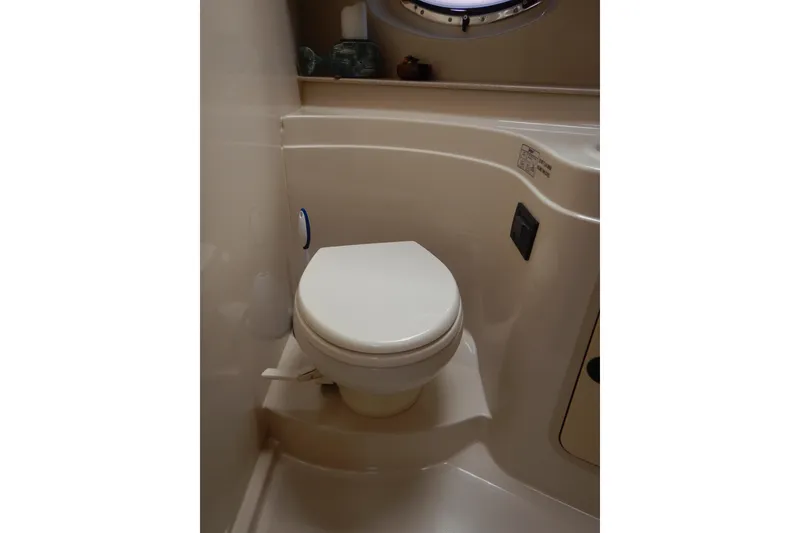 Slide: The Image of 2007 Cruisers 340 Express boat bathroom with compact toilet and porthole window. - 42