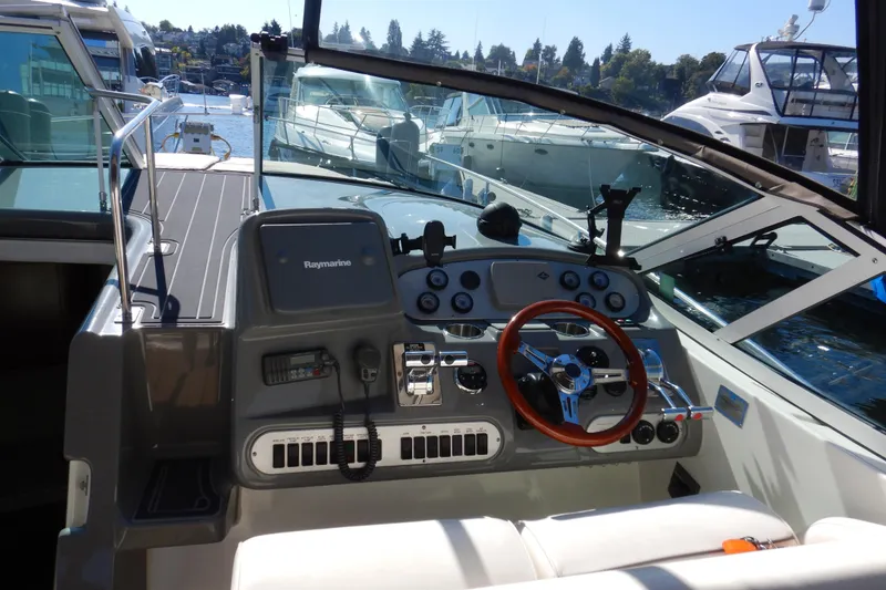 Slide: The Image of 2007 Cruisers 340 Express boat cockpit with steering wheel and control panel, docked at marina. - 5