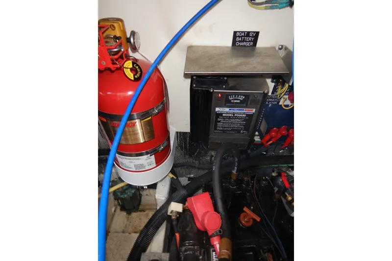 Slide: The Image of 2007 Cruisers 340 Express engine room with fire extinguisher and 12V battery charger. - 54