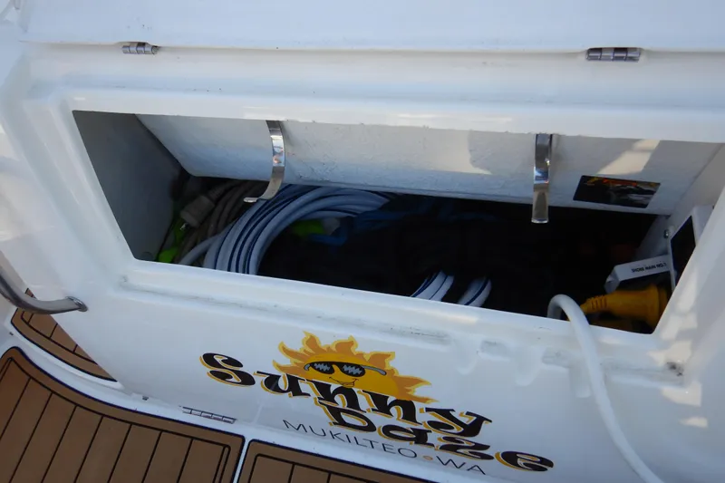 Slide: The Image of Open storage compartment on 2007 Cruisers 340 Express boat with coiled hoses and equipment. - 59