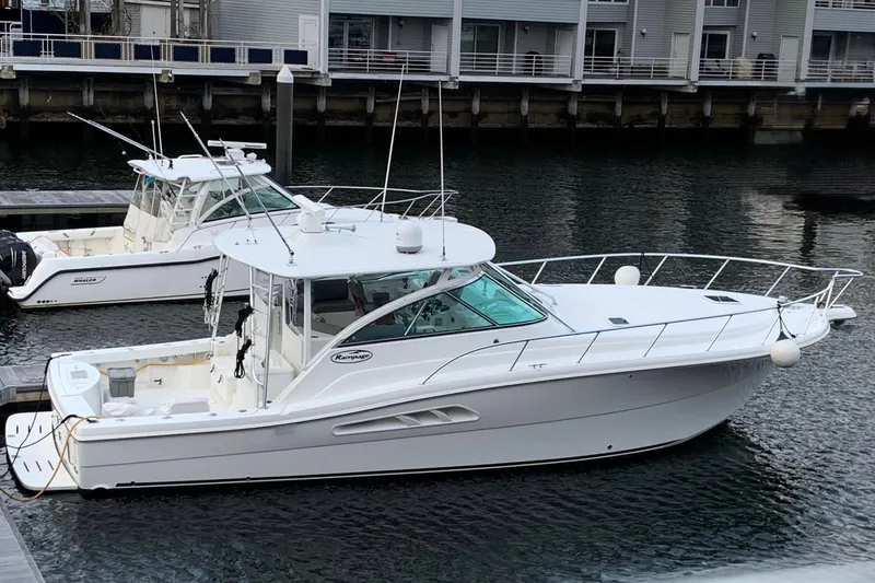The Image of 2011 Rampage 41 Express boat docked in a marina, alongside another vessel. - 0