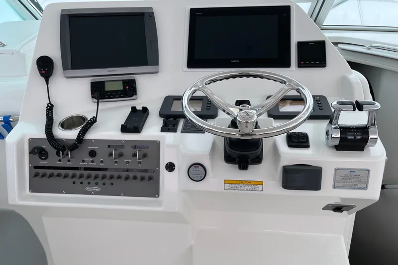 Slide: The Image of Control panel of a 2011 Rampage 41 Express boat with steering wheel and navigation screens. - 13