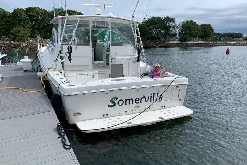 Slide: The Image of 2011 Rampage 41 Express boat docked, person relaxing on deck, labeled "Somervilla." - 2