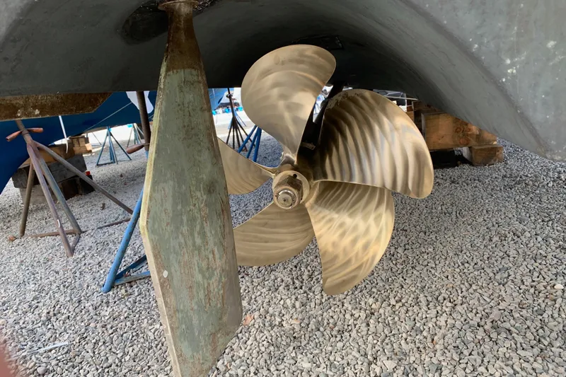 Slide: The Image of Propeller and rudder of 2011 Rampage 41 Express boat on gravel surface. - 21