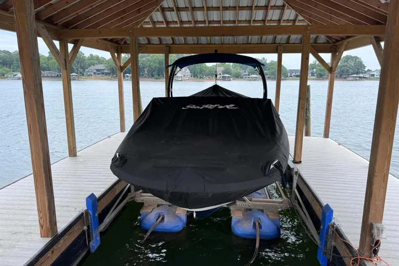 Slide: The Image of Covered 2021 Sea Ray SPX 230 boat docked under wooden shelter by the lake. - 3