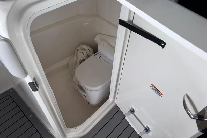 Slide: The Image of 2021 Sea Ray SPX 230 boat interior with compact marine toilet. - 21