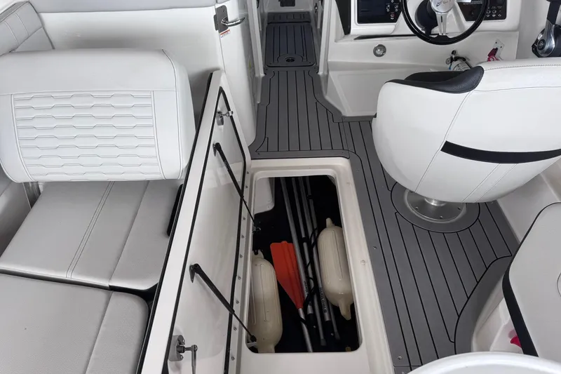 Slide: The Image of Interior of 2021 Sea Ray SPX 230 boat with white seating and storage compartment. - 22