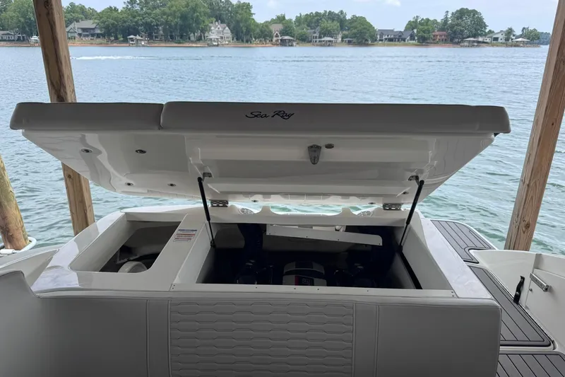 Slide: The Image of 2021 Sea Ray SPX 230 boat with open engine compartment by a scenic lake. - 23