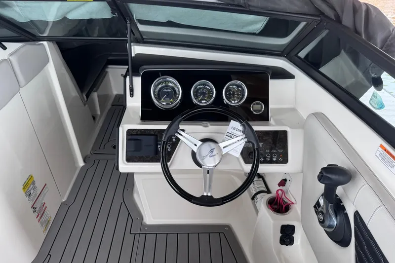 Slide: The Image of 2021 Sea Ray SPX 230 boat dashboard with steering wheel and control panel. - 7