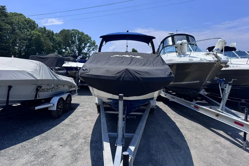 Slide: The Image of 2021 Sea Ray SPX 230 boat covered and parked on a trailer outdoors. - 1