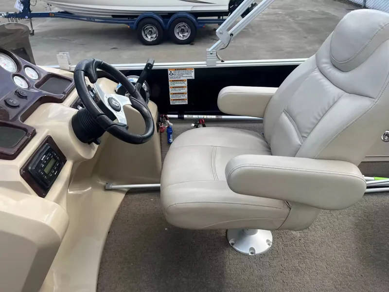 Slide: The Image of The image shows the helm of a 2015 Sylvan 8522 CNF boat with a beige captain's chair. - 10