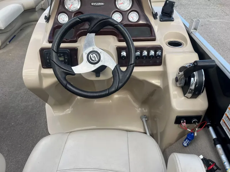 Slide: The Image of Dashboard of a 2015 Sylvan 8522 CNF boat with steering wheel and instruments. - 11
