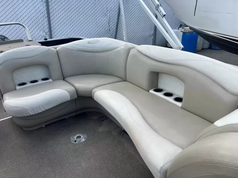 Slide: The Image of The image shows a beige, curved seating area on a boat with cup holders. - 13
