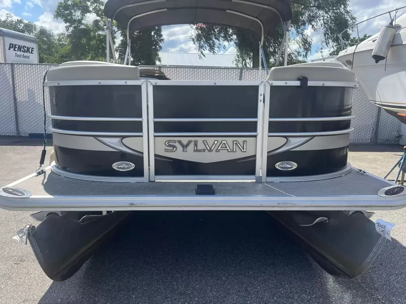 Slide: The Image of A 2015 Sylvan 8522 CNF pontoon boat is parked. It features a black and silver design. - 2
