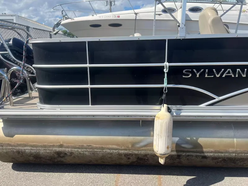 Slide: The Image of A 2015 Sylvan 8522 CNF pontoon boat is docked. It features black side panels. - 3