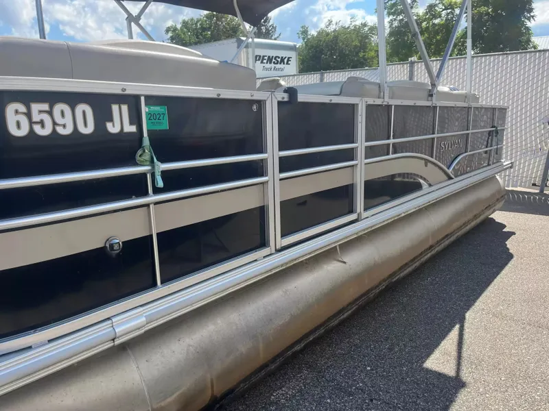 Slide: The Image of A 2015 Sylvan 8522 CNF pontoon boat is parked on a lot. It features a dark blue hull. - 4