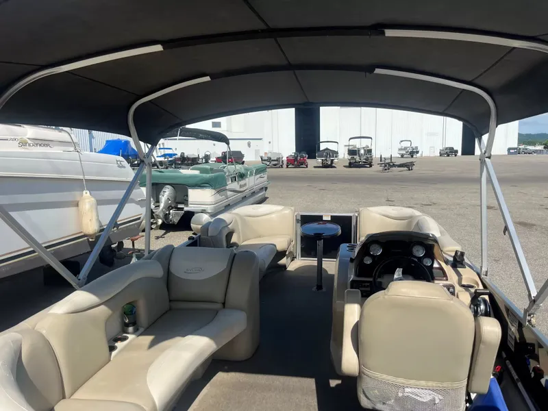 Slide: The Image of The image shows the interior of a 2015 Sylvan 8522 CNF pontoon boat with seating and helm. - 9