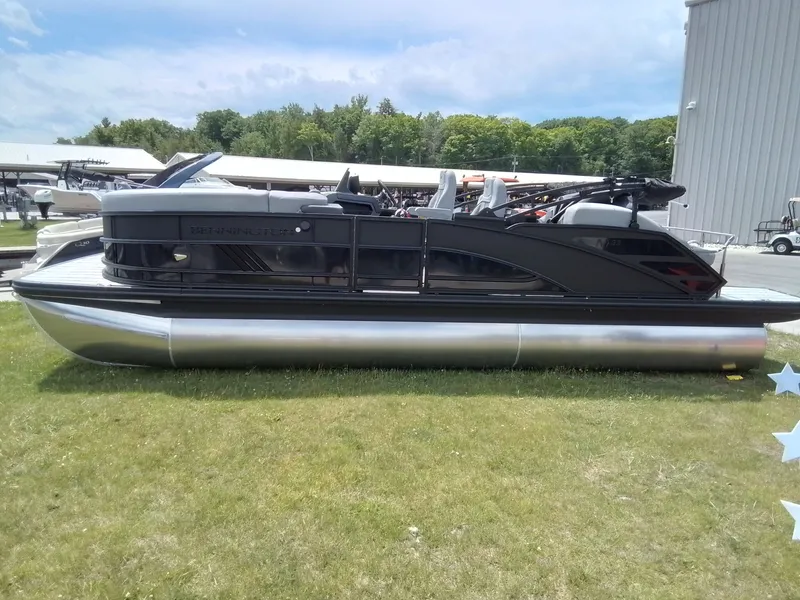 Slide: The Image of A sleek Bennington pontoon boat sits on grass, surrounded by buildings and trees. - 10