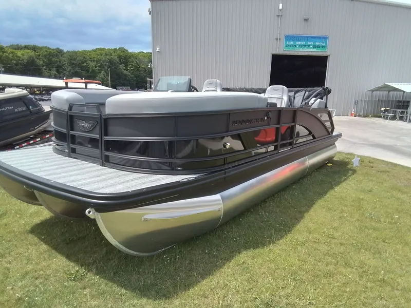 Slide: The Image of A 2026 Bennington 23M1SB pontoon boat on grass in front of a building. - 11
