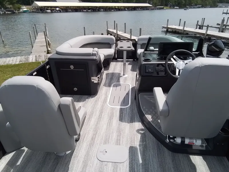 Slide: The Image of The image shows the interior of a 2026 Bennington 23M1SB pontoon boat with gray seating and a steering wheel. - 13