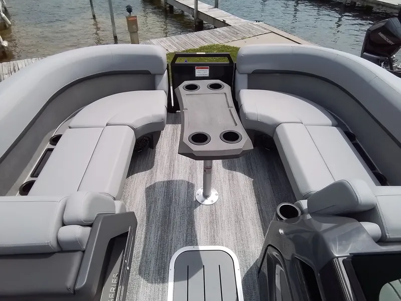 Slide: The Image of The image shows the interior of a Bennington 23M1SB pontoon boat with gray seating and a table. - 14