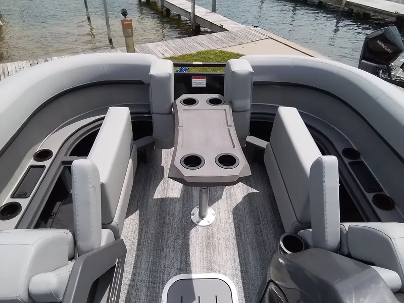 Slide: The Image of The image shows the interior of a Bennington 23M1SB pontoon boat with gray seating and a table. - 15