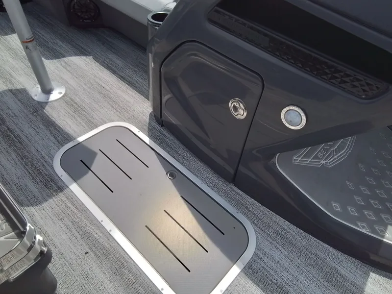 Slide: The Image of Close-up of a Bennington 23M1SB boat interior with gray flooring and storage compartment. - 22