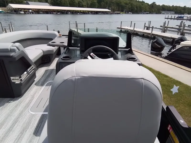 Slide: The Image of The image shows the cockpit of a Bennington 23M1SB boat with gray seats and a steering wheel. - 25