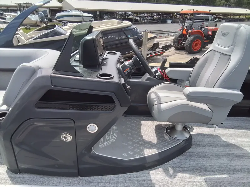 Slide: The Image of The image shows the helm of a Bennington 23M1SB boat with a gray captain's chair. - 26