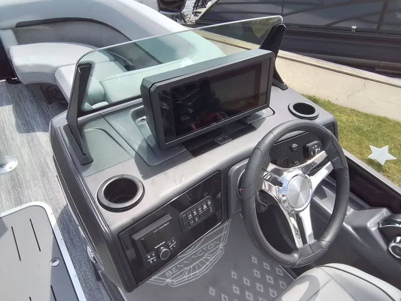 Slide: The Image of The image shows the helm of a Bennington 23M1SB boat with a modern steering wheel and large screen. - 28