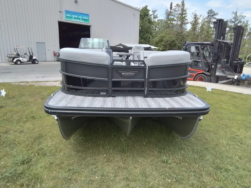 Slide: The Image of A Bennington 23M1SB pontoon boat is on grass in front of a building. - 3
