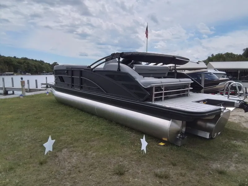 Slide: The Image of A sleek Bennington pontoon boat sits on grass beside a lake. - 7