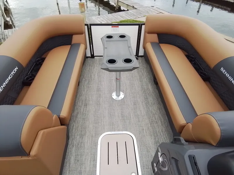 Slide: The Image of Interior of a Bennington 23SSRSF pontoon boat with beige and black seating and a table with cup holders. - 11