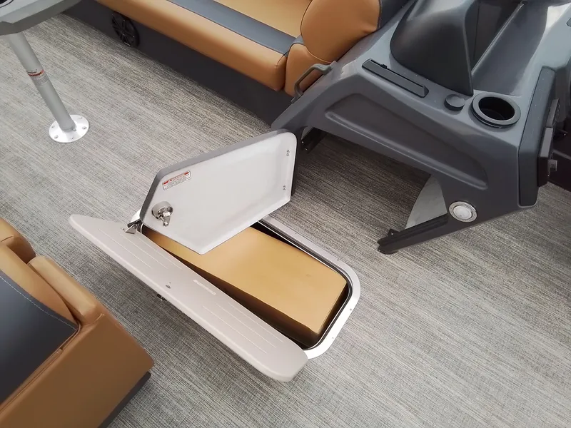 Slide: The Image of An open storage compartment on a boat with gray carpet and brown seating. - 16
