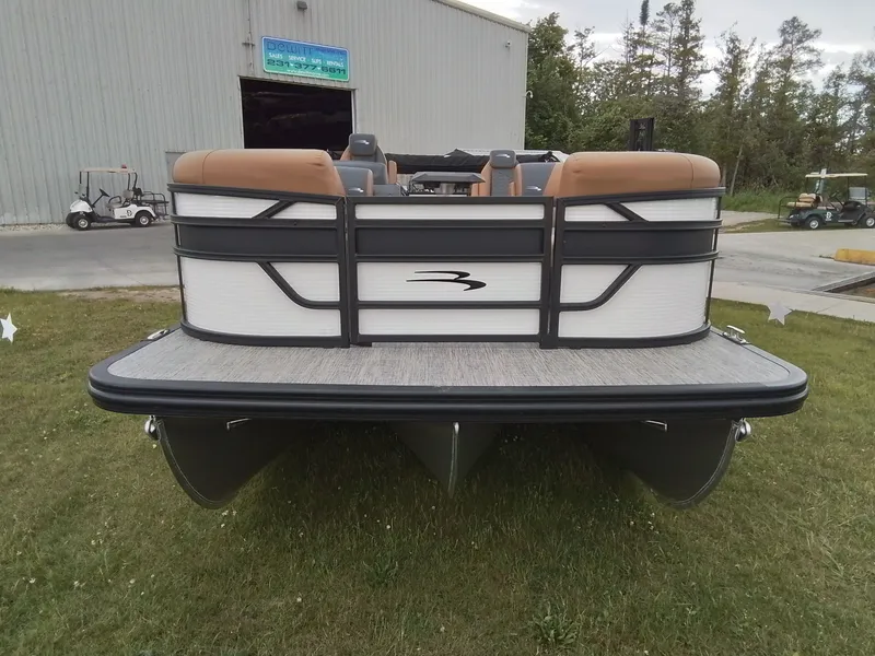 Slide: The Image of The image shows a Bennington 23SSRSF pontoon boat on grass in front of a building. - 2