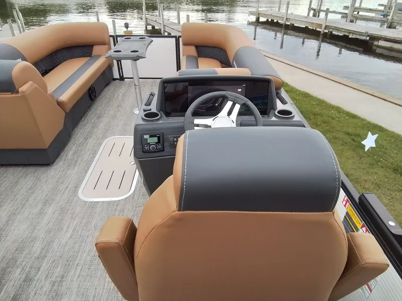 Slide: The Image of The image shows the cockpit of a Bennington 23SSRSF pontoon boat with gray and brown seating. - 22