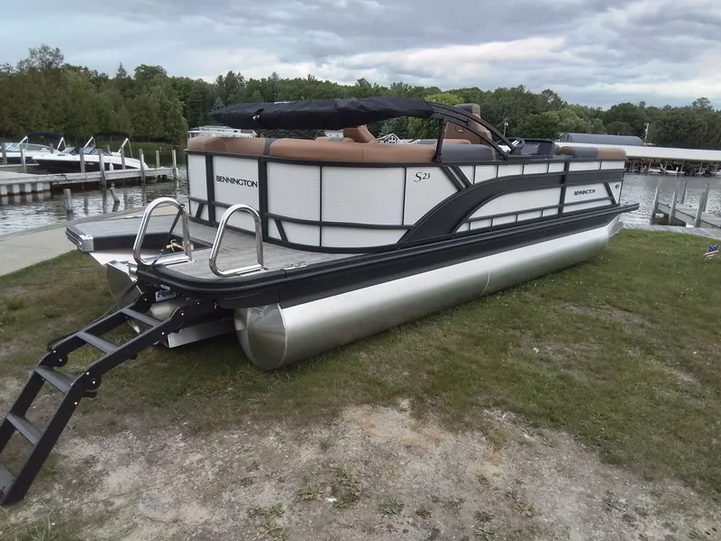 Slide: The Image of A Bennington 23SSRSF pontoon boat is on grass near a dock. - 4