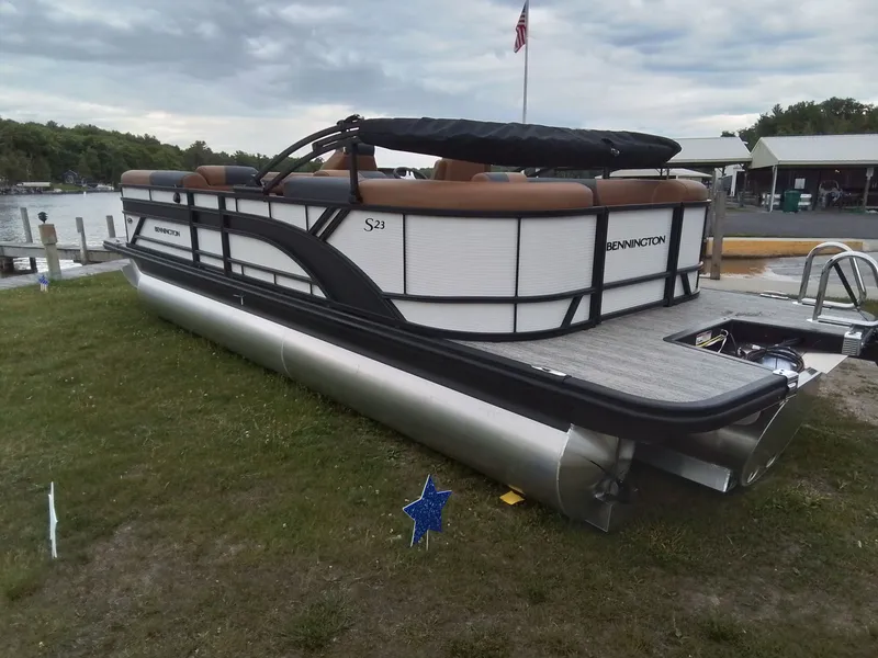 Slide: The Image of A Bennington 23SSRSF pontoon boat is on the grass by a lake. It features a modern design. - 6