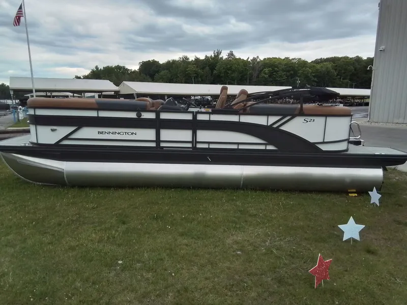 Slide: The Image of A Bennington 23SSRSF pontoon boat is on the grass beside a building. - 7
