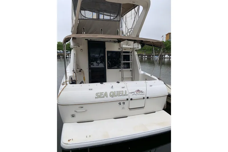 The Image of 2001 Bayliner 3258 Command Bridge boat docked, rear view with "Sea Quell" name. - 0