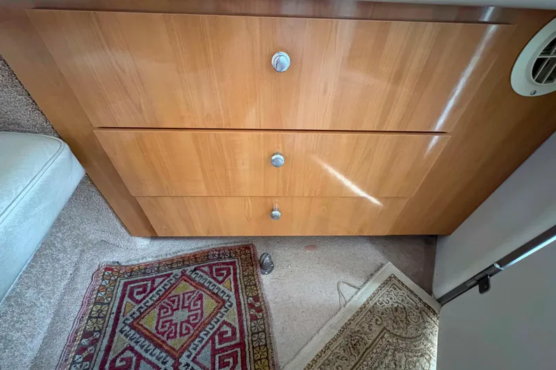 Slide: The Image of Wooden drawers and patterned rugs inside a 2001 Bayliner 3258 Command Bridge boat. - 24