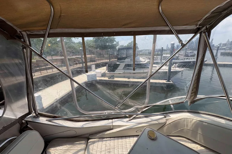 Slide: The Image of 2001 Bayliner 3258 Command Bridge interior view at marina, featuring docked boats and waterfront. - 10
