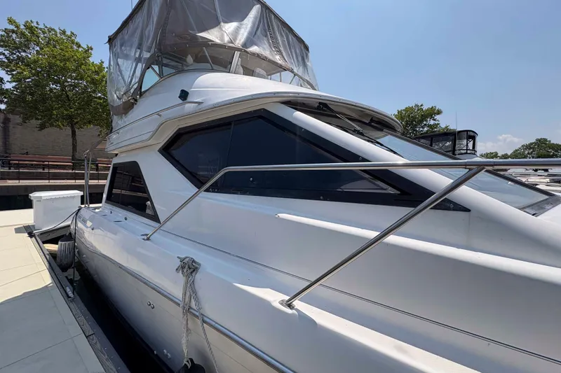 The Image of 2001 Bayliner 3258 Command Bridge yacht docked at marina under clear sky. - 0