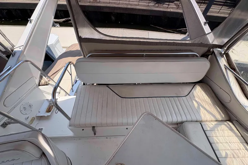 Slide: The Image of 2001 Bayliner 3258 Command Bridge interior with white seating and table. - 14